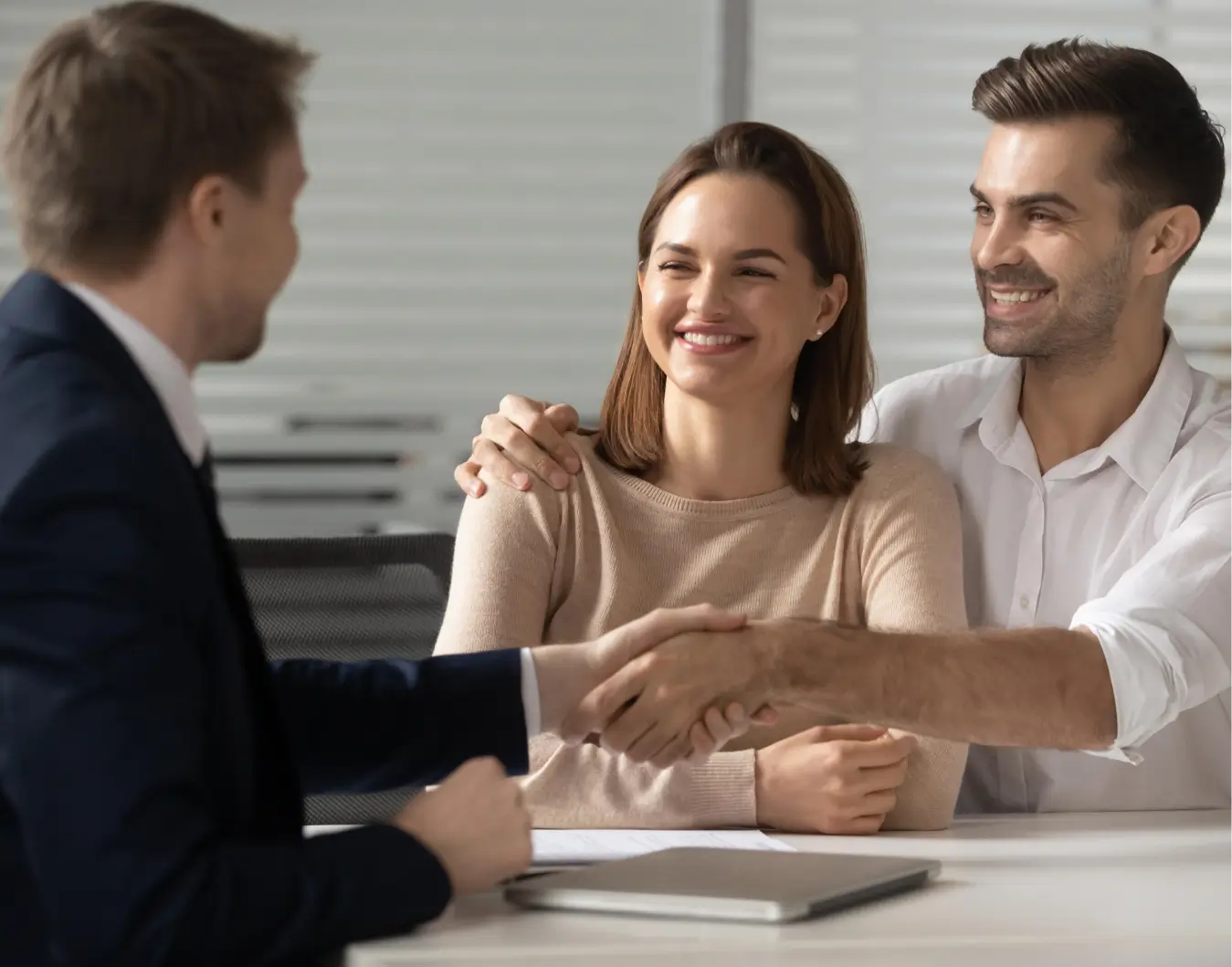 A couple shaking hands with their insurance agent